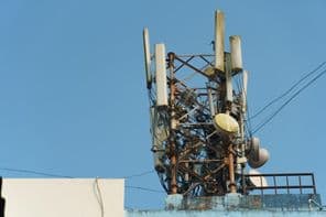 A modern GSM antennák egy magas toronyban a kék ég hátterében egy 5g jel továbbítására.