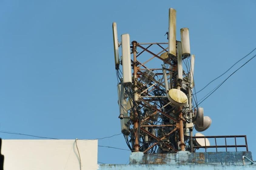 A modern GSM antennák egy magas toronyban a kék ég hátterében egy 5g jel továbbítására.