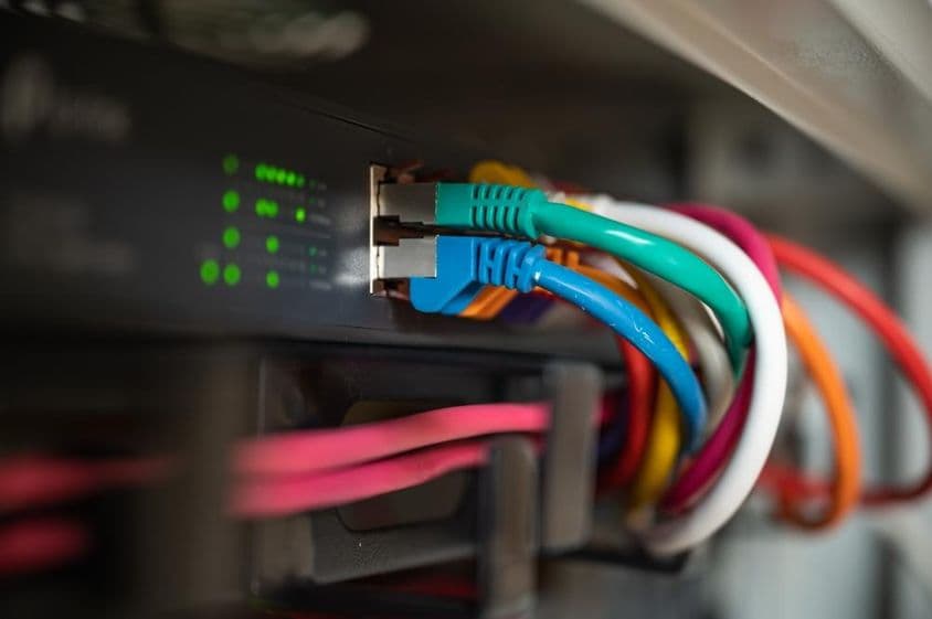 Patch panel színes LAN-kábelekkel egy adatközpont hálózati szekrényében.