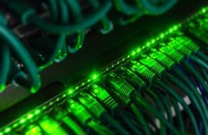 Zöld hálózati kábelek csatlakoznak fekete dobozba.