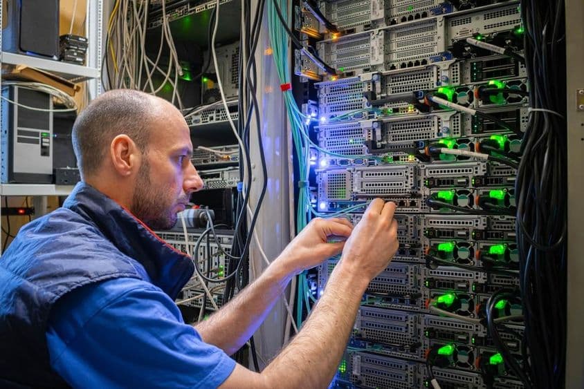 Egy technikus szerverberendezésekkel dolgozik egy adatközpontban.