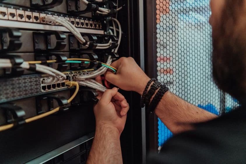 Egy technikus, aki hálózatot állít be a szerverszobában.