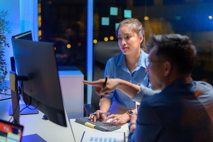 Ázsiai nő projekt menedzser és a fejlesztő elmagyarázza kód jelentését.