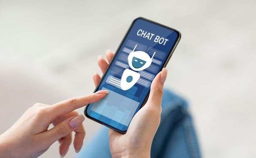 Egy nő online chat asszisztenssel kommunikál mobiltelefonján.